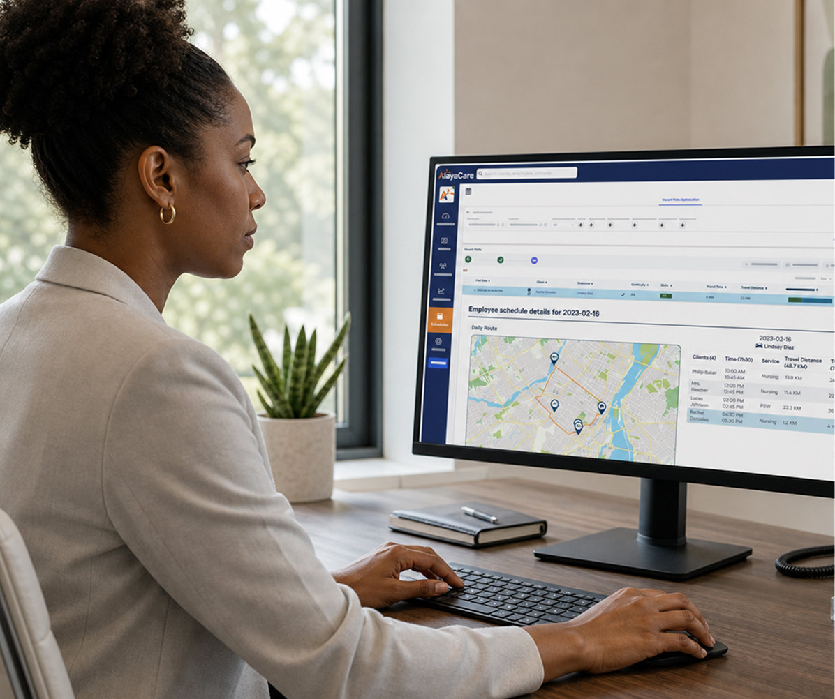 Office worker viewing an AlayaCare employee schedule and route map dashboard on a desktop monitor