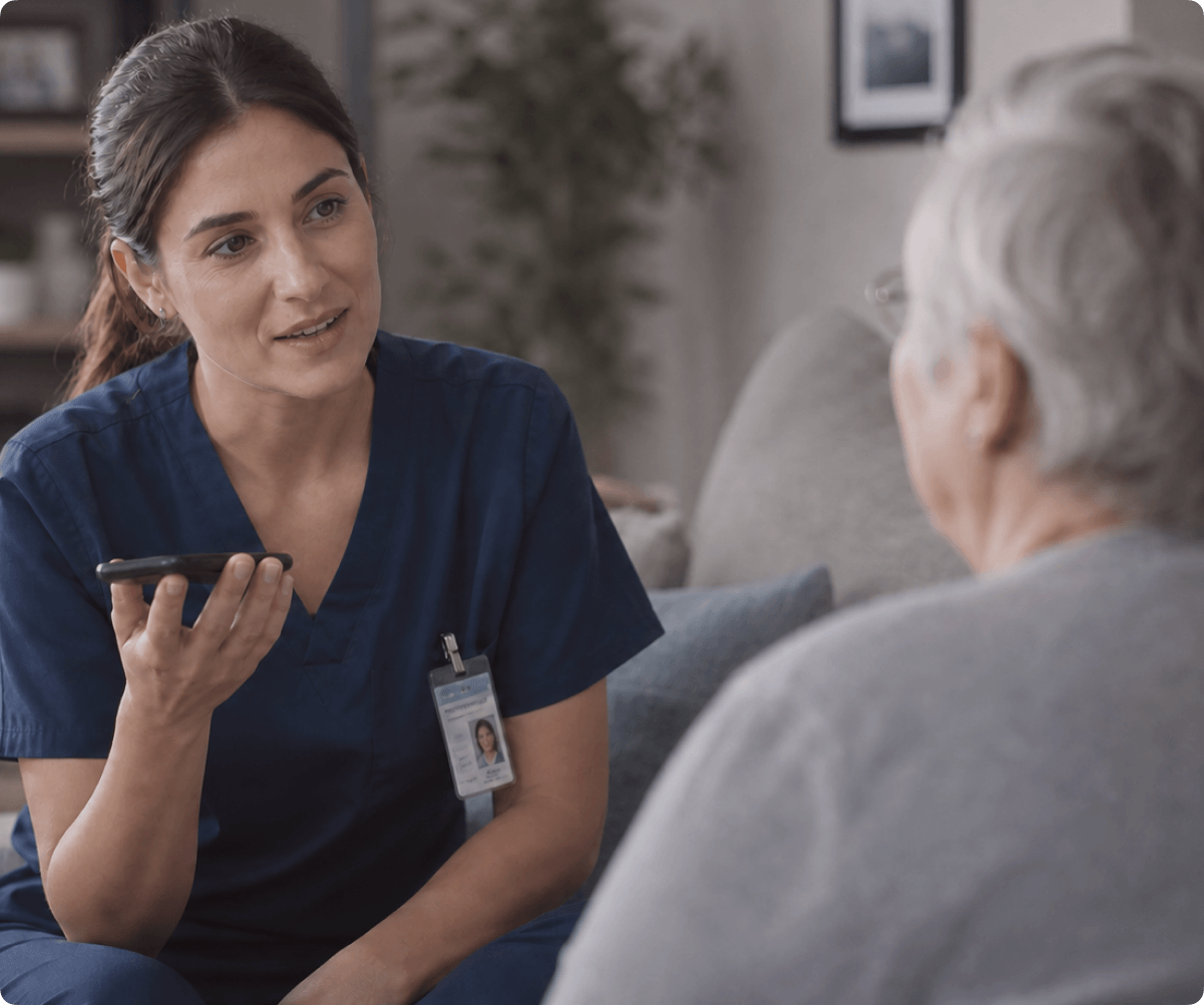 AI at AlayaCare caregiver dictating voice notes into a mobile phone during a client home visit